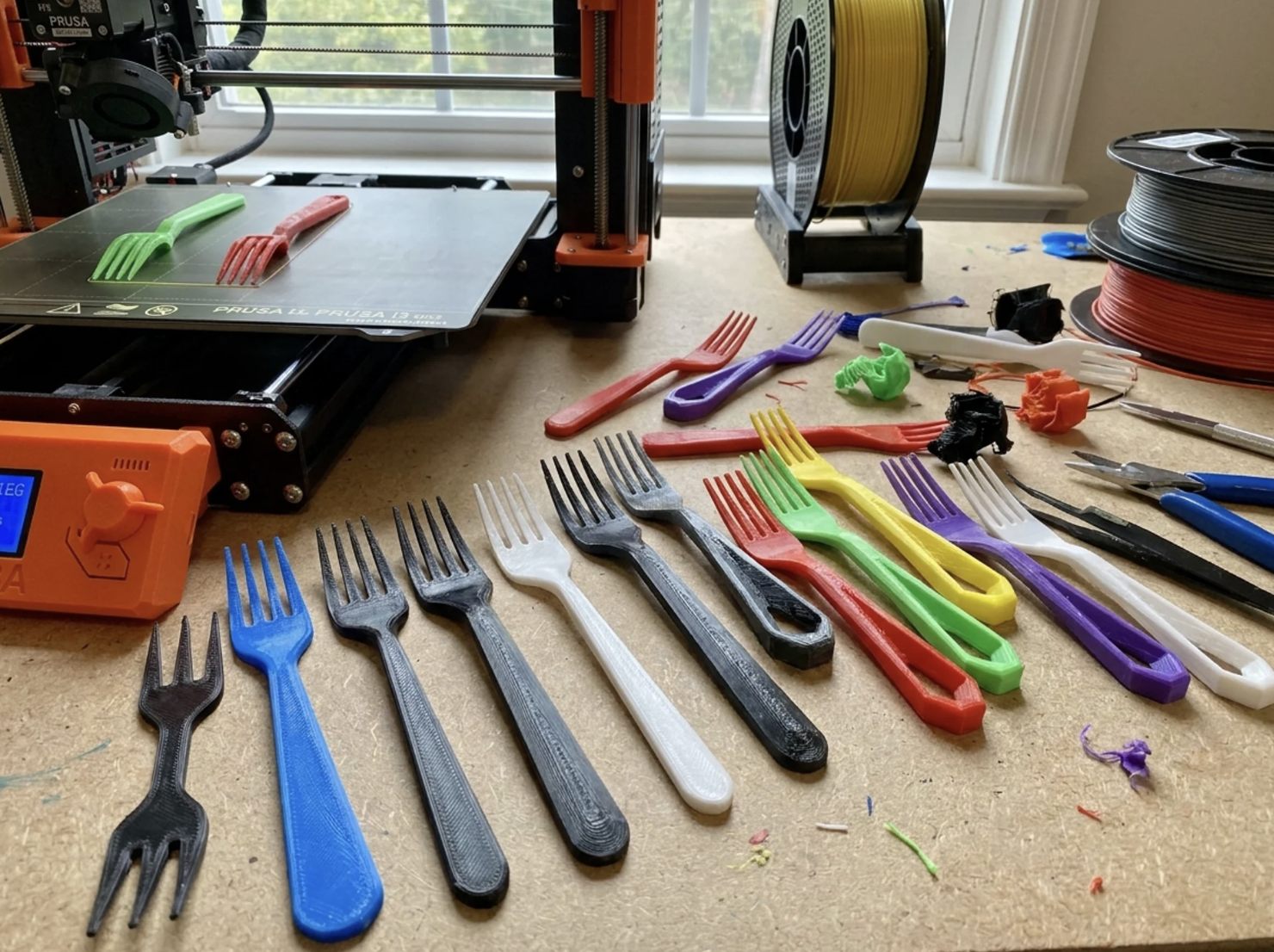 Série de fourchettes prototypées en PLA de différentes couleurs, réalisée par un apprenant